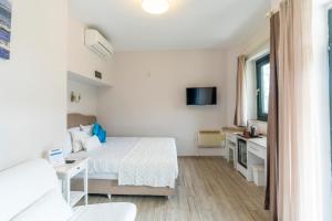 阿奇亚卡Villa Marine Hotel的一间白色卧室,配有床和电视