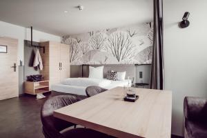 丁戈尔芬ADEBAR Stadthotel的一间卧室配有一张床和一张桌子及椅子
