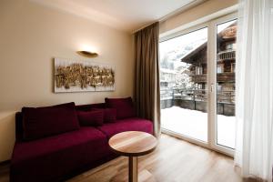 图克斯朵福帕特歌尼公寓式酒店的客厅配有紫色沙发和大窗户