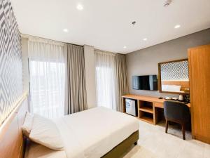 ManaoagThe Manaoag Hotel的配有一张床和一张书桌的酒店客房