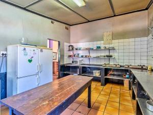 德班Tekweni的厨房配有木桌和冰箱。