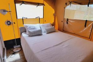 皮特斯迪亚Luxe Safari Lodge Glamping Louloudia的卧室设有一张白色大床和黄色的墙壁