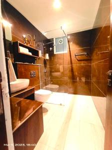 钱德加尔RONTA WORLD HOTELS的一间带卫生间和玻璃淋浴间的浴室