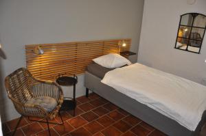 Skurup海尔特贝尔加嘉德住宿加早餐旅馆的一间小卧室,配有一张床和一把椅子