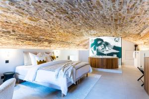 布雷斯地区布尔格Legend Majestic SPA - Insolite & Unique - Champagne - Parking privé的一间卧室设有一张床和石质天花板