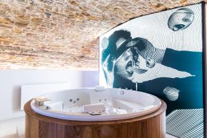 布雷斯地区布尔格Legend Majestic SPA - Insolite & Unique - Champagne - Parking privé的配有绘画的房间里设有一个浴缸