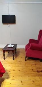 彼得马里茨堡Fabulous guest house的客厅配有红色沙发和茶几