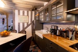 罗莫朗坦La Tour aux Grains chambres autonomes的厨房配有木制橱柜和台面