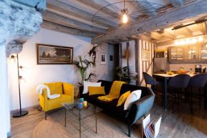 罗莫朗坦La Tour aux Grains chambres autonomes的客厅配有黑色沙发和黄色椅子