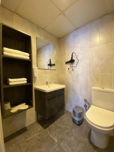 吉拉克Pin Suite Hotel的一间带水槽、卫生间和镜子的浴室