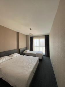 吉拉克Pin Suite Hotel的酒店客房设有两张床和窗户。
