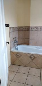 彼得马里茨堡Fabulous guest house的带浴缸的浴室和瓷砖地板。