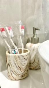 埃里温La Casa de Armenie的浴室柜台旁边盥洗盆的木制牙刷架