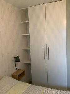 卑尔根Atelier Zonnehoek的卧室配有白色橱柜和1张床