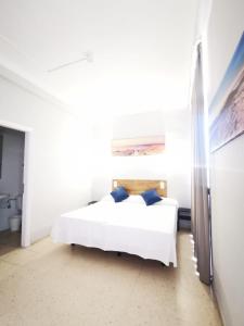 拉克鲁斯Hotel Don Cándido的一间卧室配有白色床和蓝色枕头
