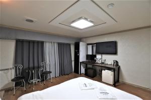 大田Hani Motel的酒店客房配有一张床、一张书桌和一台电视。