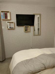 圣迪耶jujuouragan的卧室配有一张壁挂式平面电视的床。