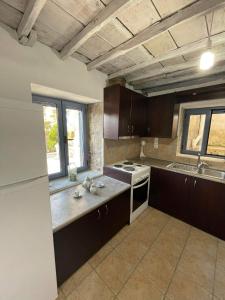 孔蒂亚斯Kontias stonehouse 2的厨房配有棕色橱柜和白色冰箱