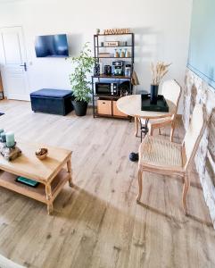 GranguesLe Cotil Ribes的客厅铺有木地板,配有桌椅。