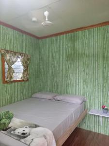 莫阿尔博阿Green Acres Village的绿条纹墙壁间的一张床位