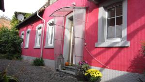 葡萄酒之路上的诺伊施塔特Winzeranwesen - Weingut Christian Eberley - Haupthaus I MINDESTAUFENTHALT 3 NÄCHTE - MINIMUM STAY 3 NIGHTS的红色的建筑,有门和窗户