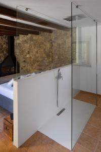 比拉克尔慕Somnis de l´Empordà的卧室内的玻璃淋浴间,配有床