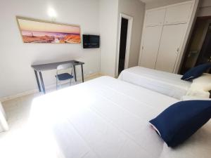 拉克鲁斯Hotel Don Cándido的酒店客房设有两张床和一张桌子。