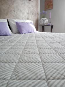 Appartamento Lavanda - Casa vacanza nel Delta del Po的一张白色大床,上面有紫色枕头