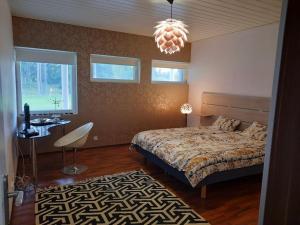 波里Villa Kilpäkki的卧室配有床、桌子和窗户。