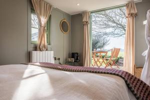 WangfordToad Hall Lodges - Luxury Eco Lodges Near Southwold!的一间卧室设有一张床和一个大窗户