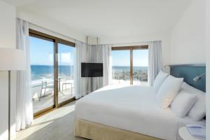 多列毛利诺斯Hotel Ocean House Costa del Sol, Affiliated by Meliá的一间卧室设有一张大床和一个大窗户