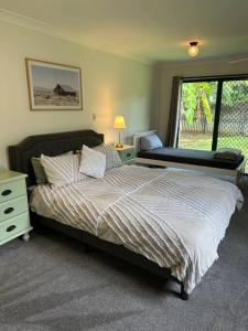 马里巴Cosy Queenslander in the heart of town.的一间卧室设有一张大床和一个窗户。