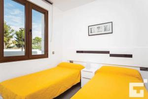 卡尔佩Villa Mirador de Bassetes 4 - Grupo Turis的配有两张床铺的黄色床单和窗户