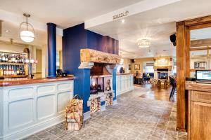 SouthboroughThe Hand & Sceptre by Innkeeper's Collection的厨房设有蓝色的墙壁和壁炉。