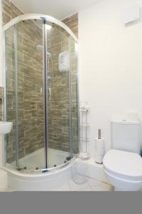 StanningleyNazarene apartments in Leeds的浴室设有玻璃淋浴间和卫生间