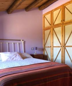 Folgoso de la CarballedaCASA RURAL LA TI ISABEL的一间卧室设有一张床和一个大型木门