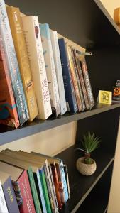 大吉岭Trippers hostel的书架上一排书,有盆栽