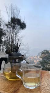 大吉岭Trippers hostel的茶壶和茶几上的杯子
