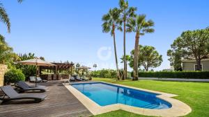 马贝拉Villa Maracana的一座别墅,设有游泳池和棕榈树