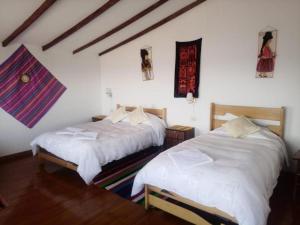 Comunidad YumaniHostal Inca Uma的配有白色床单的客房内的两张床