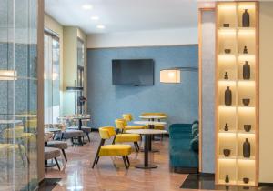 埃尔切Hotel Elche Centro , affiliated by Melia的一间带桌椅和电视的用餐室