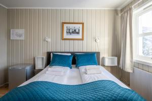 摩城Mo Gjestegård的一间卧室配有一张带蓝色枕头的大床