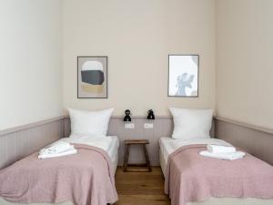 柏林Schoenhouse Avenue - Digital Access的配有白色墙壁和粉红色毯子的客房内的两张床