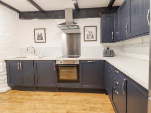 斯基普顿The Eller Beck的厨房配有海军蓝的橱柜和水槽