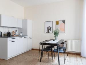 柏林Schoenhouse Avenue - Digital Access的厨房配有白色橱柜和桌椅