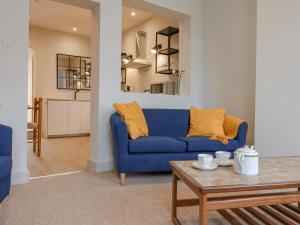 海斯Castle Cottage的客厅配有蓝色的沙发和桌子