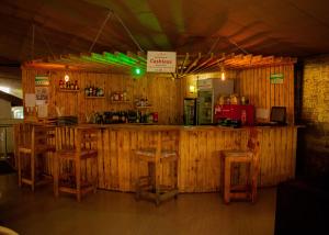 SiayaDistinction Gardens的餐厅内的酒吧,设有木墙和凳子