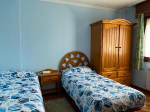 维拉桑纳·德·梅纳VACACIONES VILLASANA的一间卧室配有一张床和一个木制梳妆台