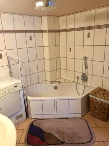 Mengersgereuth-HämmernAuszeit - a84018的带浴缸的浴室和墙上的电话