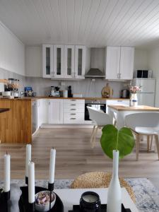 奥勒松Light home apartment Alesund with free parking的厨房配有白色橱柜和植物桌子